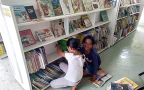 Local children shelving books in Tonga's first public library
