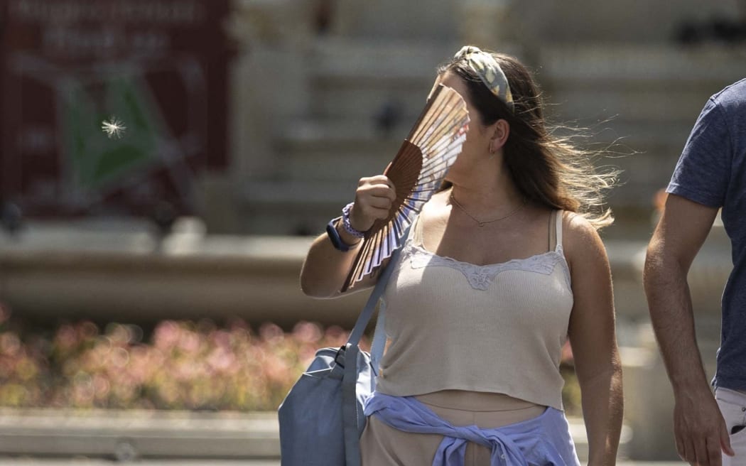LONDON, UNITED KINGDOM - JULY 18: A woman, using a fan, is seen as heatwave hits London, United Kingdom on July 18, 2022. The UK Meteorological Service (Met Office) issued an extreme temperature warning that temperatures could reach 40 degrees Celsius, posing a serious risk on health. The "red" alert for extreme temperatures that affect adversely travel, health services and education will last until July 19th. Rasid Necati Aslim / Anadolu Agency (Photo by Rasid Necati Aslim / ANADOLU AGENCY / Anadolu Agency via AFP)