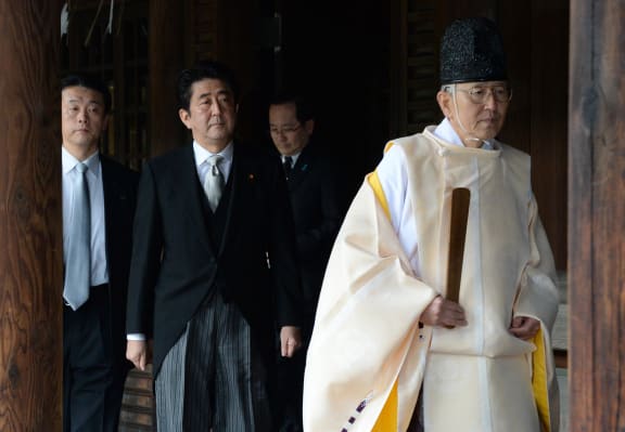A Shinto priest leads Prime Minister Shinzo Abe at the Yasukuni war shrine.
