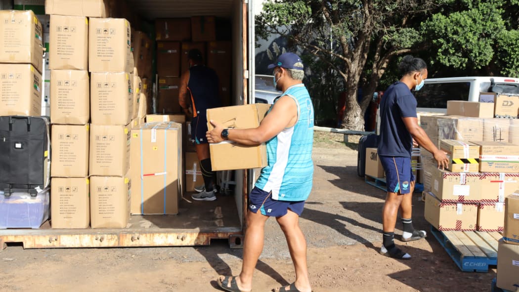 Moana Pasifika players Isi Tu'ungafasi and Don Lolo Penitau Finau loading up the containers of supplies for Tonga