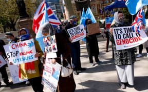 Members of the Uyghur community and human rights activists demonstrate outside the Houses of Parliament in London on 22 April 2021.