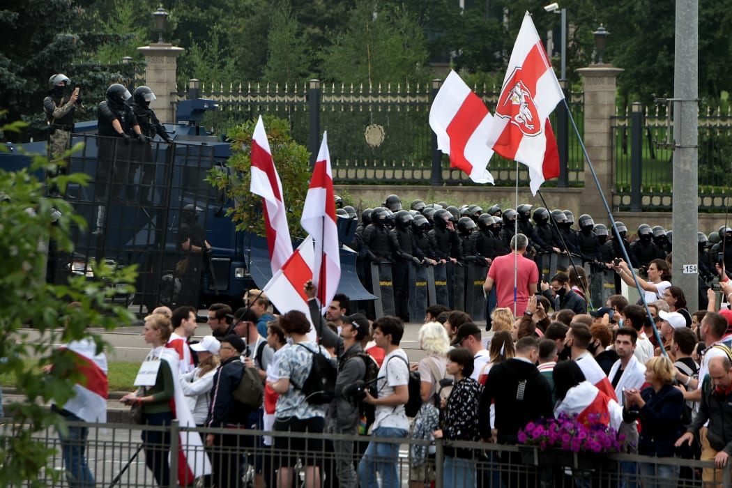 Demonstrators gather in front of law enforcement officers blocking an area in front of the Independence Palace.