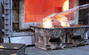 Skimming melted aluminum for removing the dross before casting.