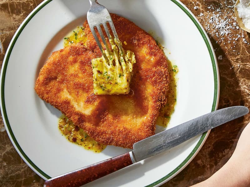 A round piece of schnitzel with a square of butter on top.