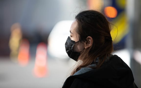 A woman wearing a face mask during the second day of the SkyCity fire.