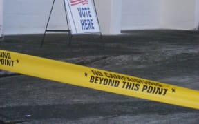 A “Vote Here” sign, with yellow tape “no campaign beyond this point” is a common scene for voters entering one of the 44-polling stations in American Samoa.