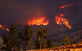 The smoke and flames of the Hughes Fire are seen near Castaic Lake, California, on Wednesday.