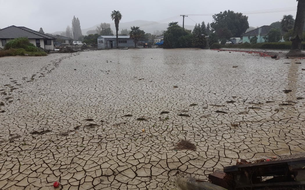 The silt-covered and cracked path in Waiohiki, Napier after Cyclone Gabrielle.