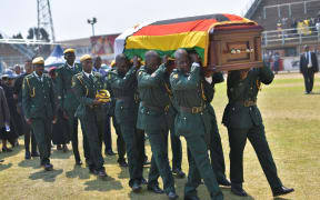 Soldiers in ceremonial uniform carry the casket of Zimbabwe's former President, the late Robert Mugabe after it arrived at Rufaro stadium on September 13, 2019.