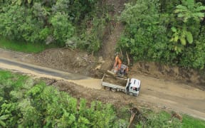 A worker clears a slip on SH3.