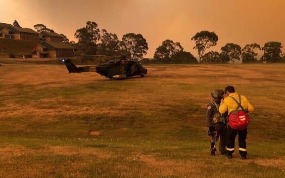 A Navy MRH-90 helicopter from 808 Squadron on a field at a residential area in the Omeo and Mt Hotham area of Victoria state, as part of evacuations during bushfire relief efforts.