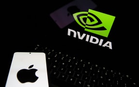 The Apple logo appears on a phone and the Nvidia logo is displayed on a laptop in Krakow, Poland, on April 1, 2025.