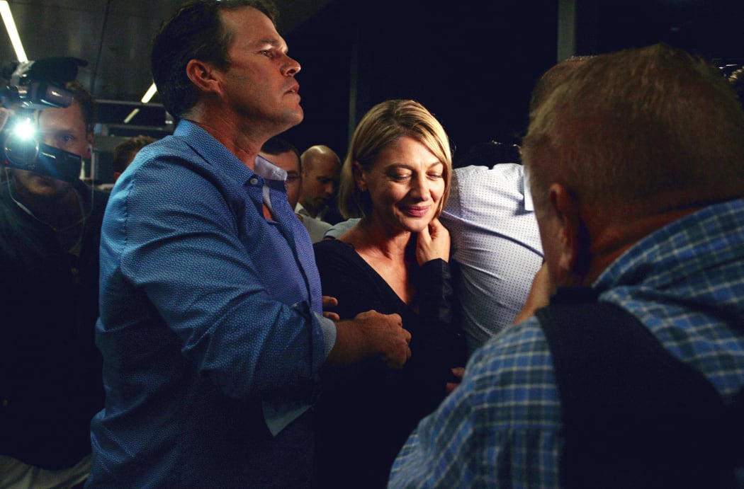 Australian television presenter Tara Brown (C) walks through a media scrum in Sydney airport on April 21, 2016, after she and her crew were released on bail from prison in Beruit.