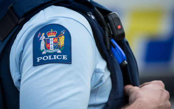 Close up of a police officer at an incident on a residential street. 6 July 2016.