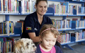 Charlie Brown the shih tzu cross listens as Ivy reads.