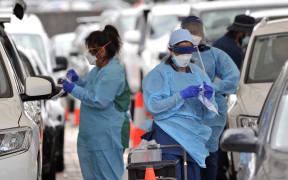 Health workers conduct PCR tests at the St Vincent's Bondi Beach COVID-19 drive through testing clinic on 22 December 2021 in Sydney.