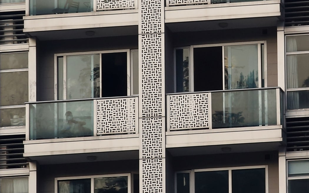 A policeman checks the balcony of the unit where two women's bodies were found in Hong Kong's Wanchai district.