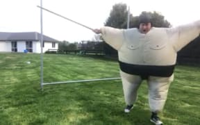 A man celebrates waving a pole around.