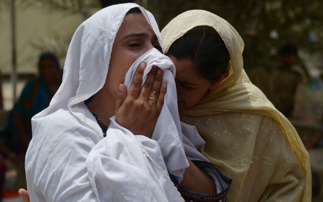 Pakistani relatives mourn the death of a heatstroke victim outside a hospital in Karachi on June 23, 2015