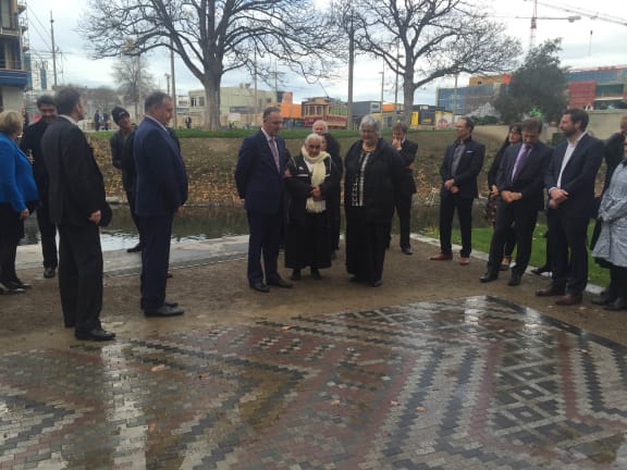 John Key inspects one of 13 Nga Whariki Manaaki (stone weaving patterns) paved along Christchurch's Avon River.