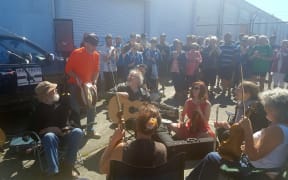 Yachtsman Enda O'Coineen, standing, joins well-wishers in Dunedin before departing.