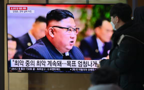People watch a television screen showing news footage of North Korean leader Kim Jong Un attending the 8th congress of the ruling Workers' Party held in Pyongyang, at a railway station in Seoul on January 6, 2021.
