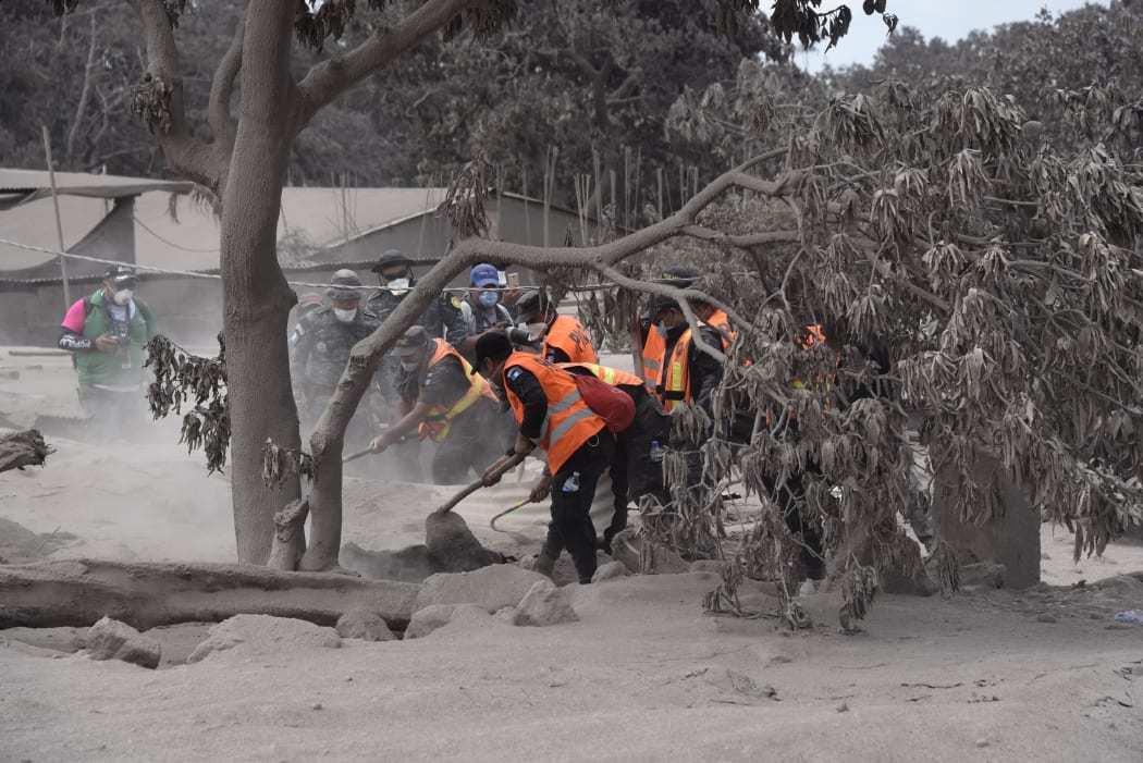 Members of Guatemalan Army and police officers, search for victims in the ash-covered village of San Miguel Los Lotes, in Escuintla department, about 35 km southwest of Guatemala City, two days after the eruption of the Fuego Volcano, on June 5, 2018.