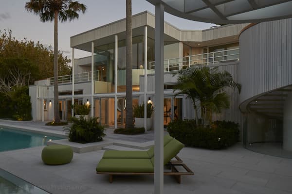 Large designer house with a pool and palm trees around the exterior