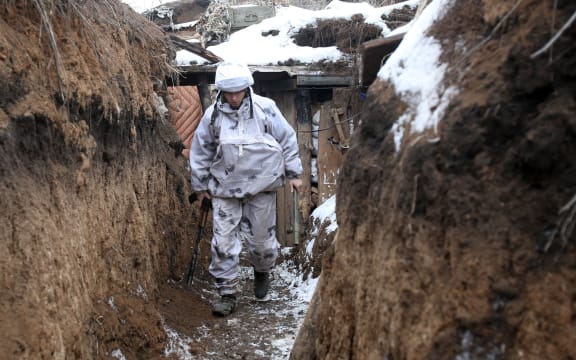 A Ukrainian serviceman walks along a snow covered trench on the front line with the Russia-backed separatists near Verkhnetoretskoye, in the Donetsk region on 1 February 2022.