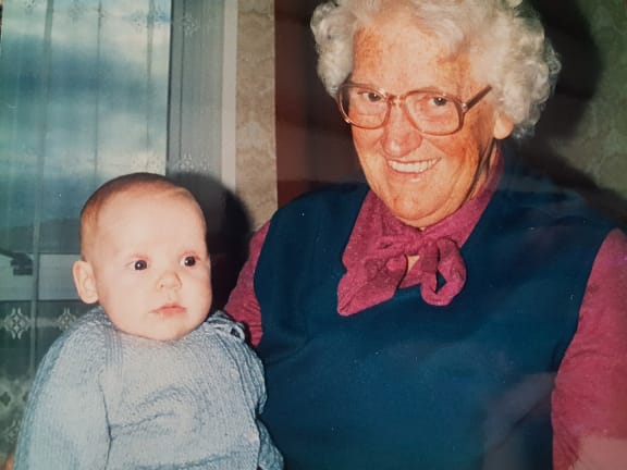 An image of a smiling Isobel Robson holding her infant granddaughter Sarah on her knee.