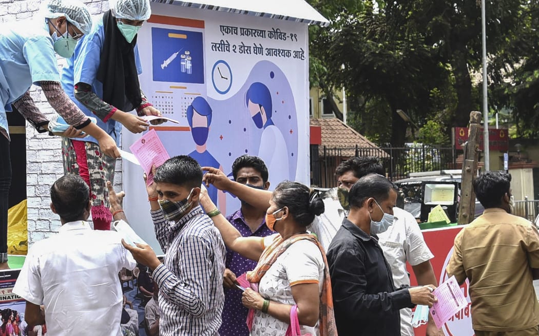 Workers of the Brihanmumbai Municipal Corporation (BMC) distribute face masks during an awareness campaign against the spread of the Covid-19 coronavirus, in Mumbai on April 8, 2021.