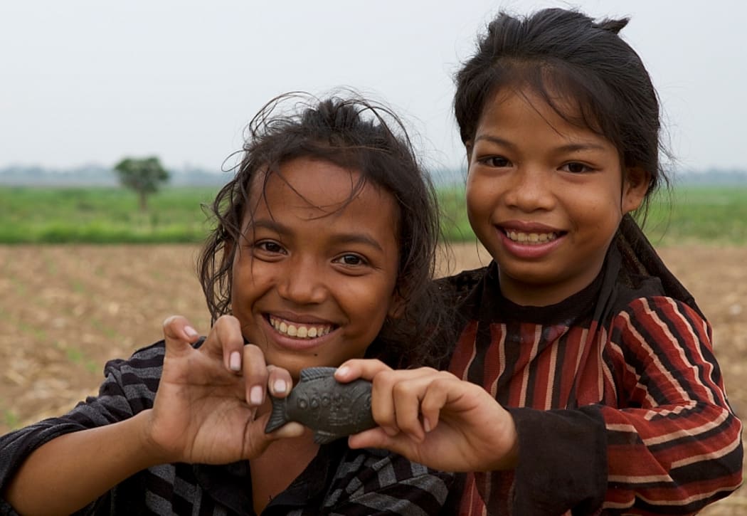 Children in Cambodia with an Iron Fish.
