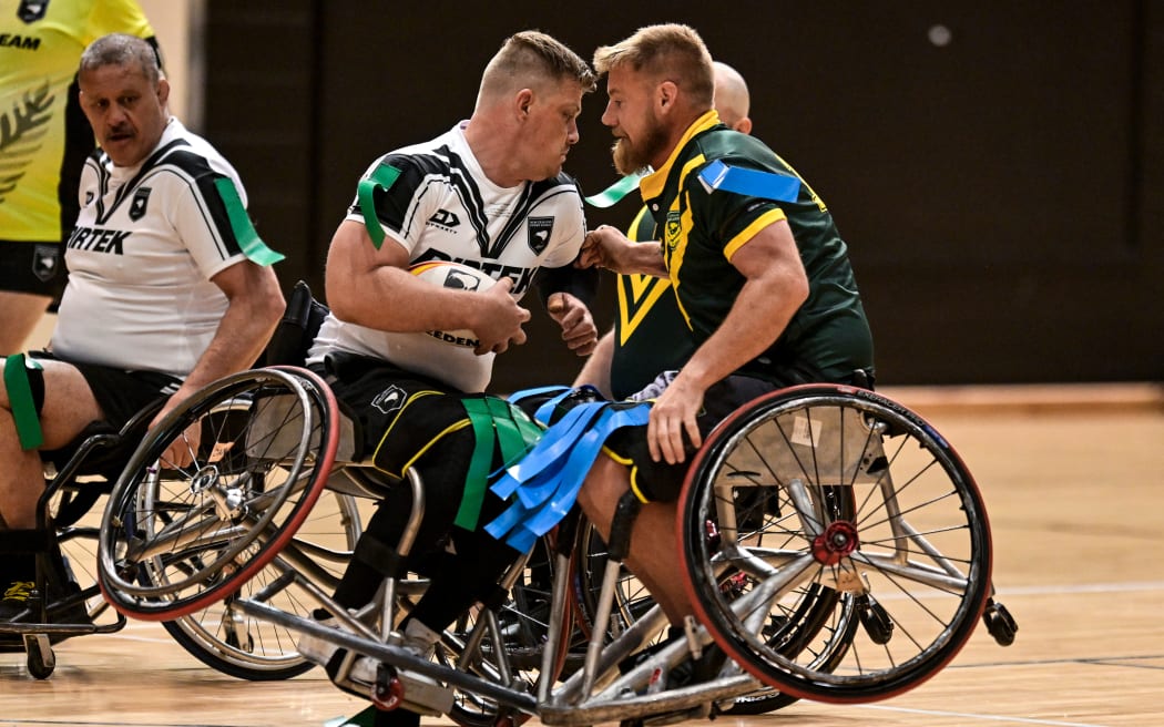 Dan Scott of New Zealand (L) and Zac Schumacher of Australia clash in a wheelchair rugby league test in Auckland.