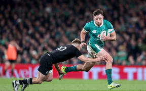 Ireland’s Mack Hansen tries to evade All Black Damian McKenzie in a test match at Aviva Stadium in Dublin, 8 November, 2024.