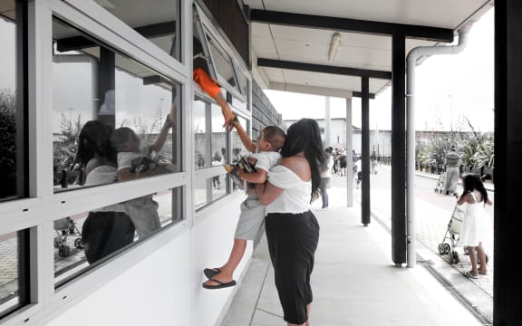 "Bye bye Dadda" a boy reaches for one last goodbye to his father before heading outside the prison walls