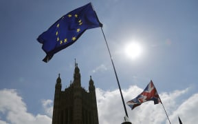 Protestor flags fly opposite the Houses of Parliament in London, Thursday, April 11, 2019.