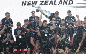 Team New Zealand's skipper Peter Burling (C) holds the America's Cup, affectionately known as the Auld Mug, after winning the 36th America's Cup against Luna Rossa Prada in Auckland on March 17, 2021.
