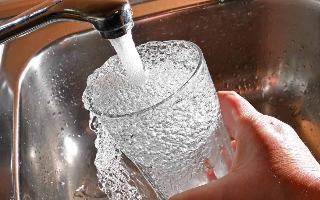 Tap water pouring into a glass.