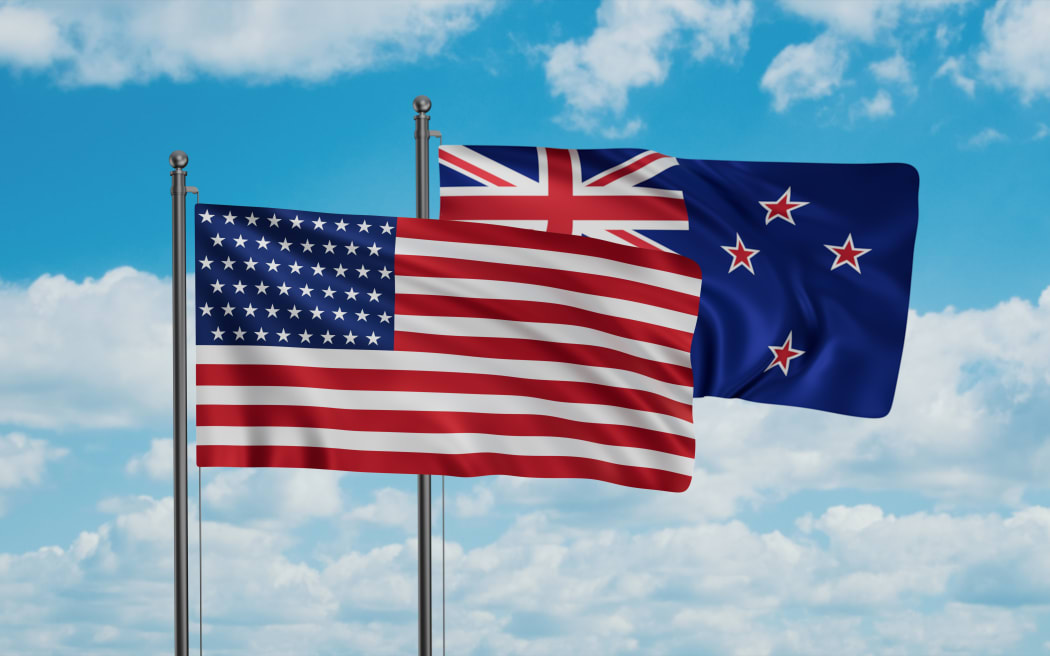 New Zealand and USA flag waving together in the wind on blue sky, two country cooperation concept
