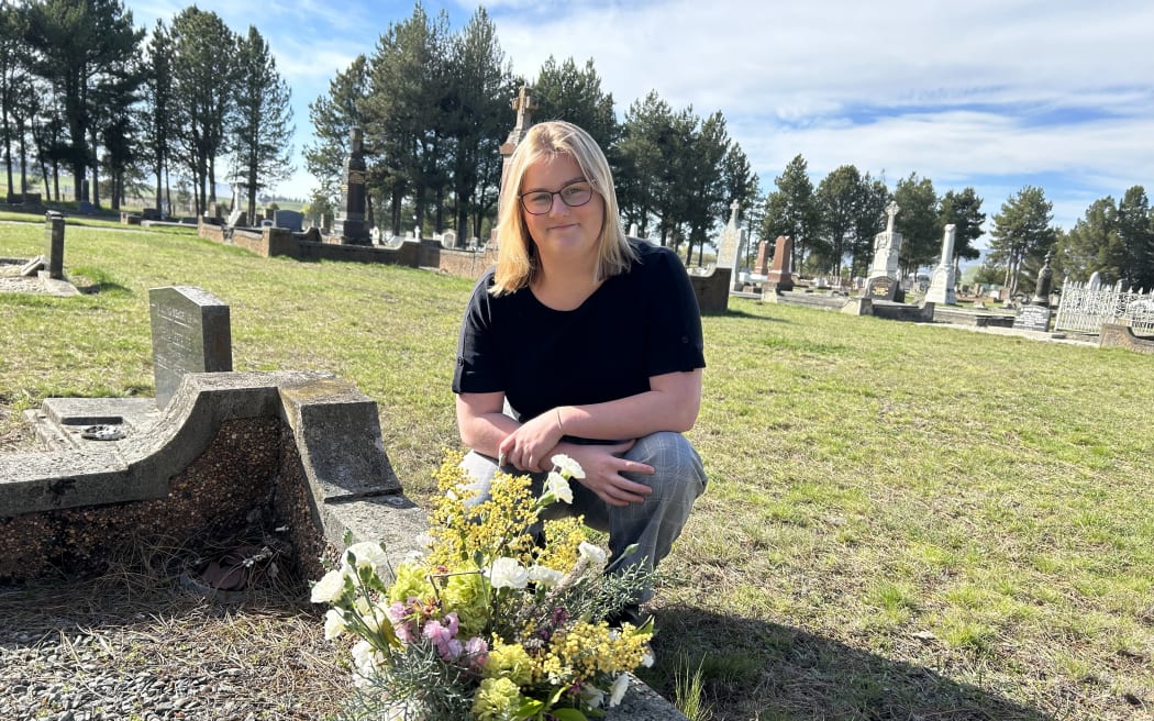 Central Otago District Council cadet Jocelyn Ryan laying flowers on the only unknown grave at Ranfurly Cemetery,