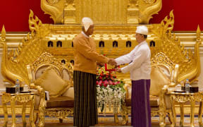 New Myanmar president Htin Kyaw, left, receives the presidential seal from outgoing president Thein Sein during the handover ceremony on 30 March.