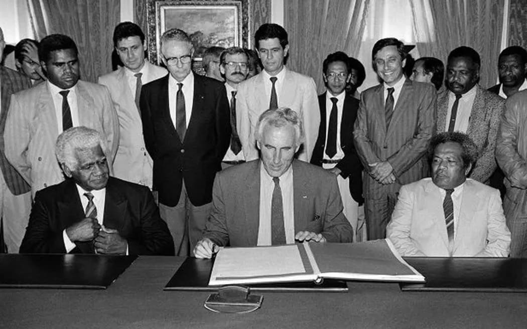 Louis Le Pensec (centre) with pro-France politician Dick Ukewei (left) and pro-independence leader Jean-Marie Tjibaou (right) signing the Oudinot Accord on 29 August 1988.