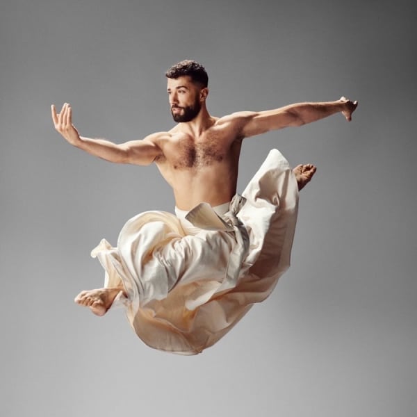 Ahmad Joudeh - a man in a flowing skirt - leaps in the air.