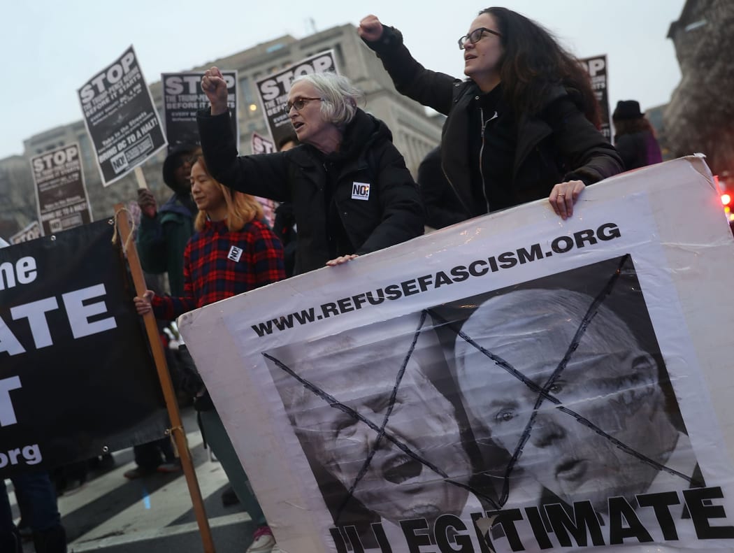 Protesters join together for a rally and march "to prevent the Trump/Pence regime from coming to power," on January 17, 2017 in Washington, DC.