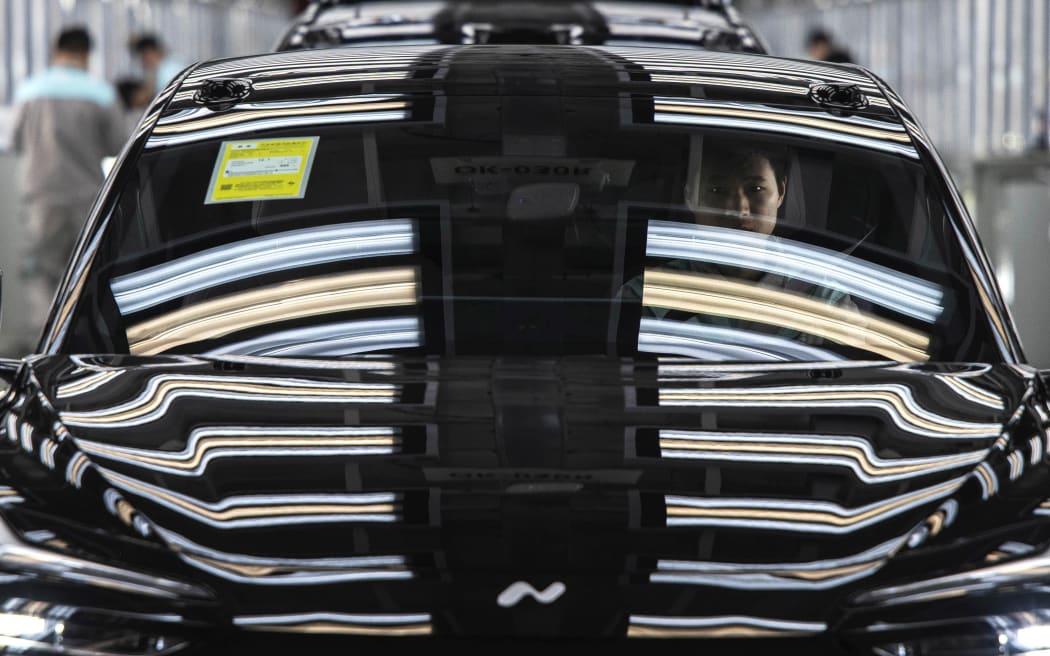 A worker from Chinese electric vehicle company NIO sits in a car during its final inspection at the end of the automated production line at the company's manufacturing hub in Hefei, China, on January 17, 2025.
