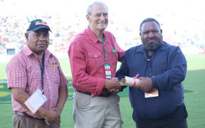 Don Fox receiving his PNGRFL life membership from Chairman Sandis Tsaka in 2019, accompanied by CEO Reatau Rau.