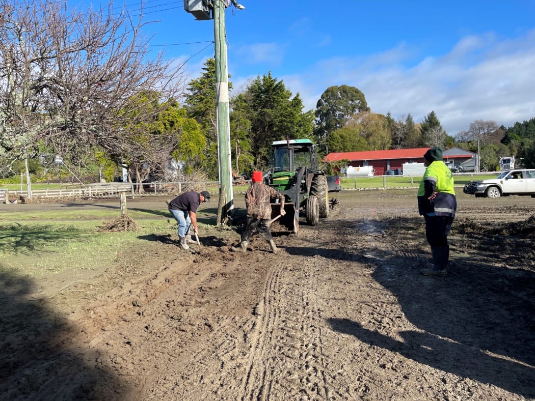 Workers start the clean-up after floods damaged roads and walkways in Tokomaru  Bay.