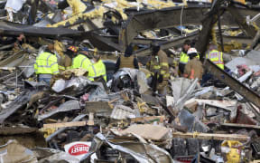 Emergency workers search what is left of the Mayfield Consumer Products Candle Factory after it was destroyed by a tornado in Mayfield, Kentucky, on 11 December 2021.