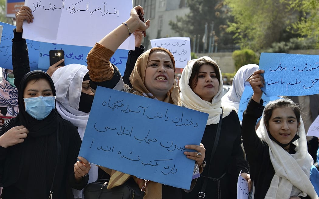 Afghan women and girls take part in a protest in front of the Ministry of Education in Kabul on March 26, 2022, demanding that high schools be reopened for girls. (Photo by Ahmad SAHEL ARMAN / AFP)