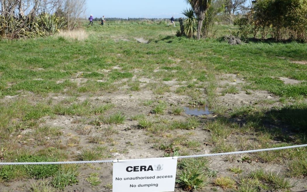 Children dash through a red zone property in Kairaki, north of Christchurch.